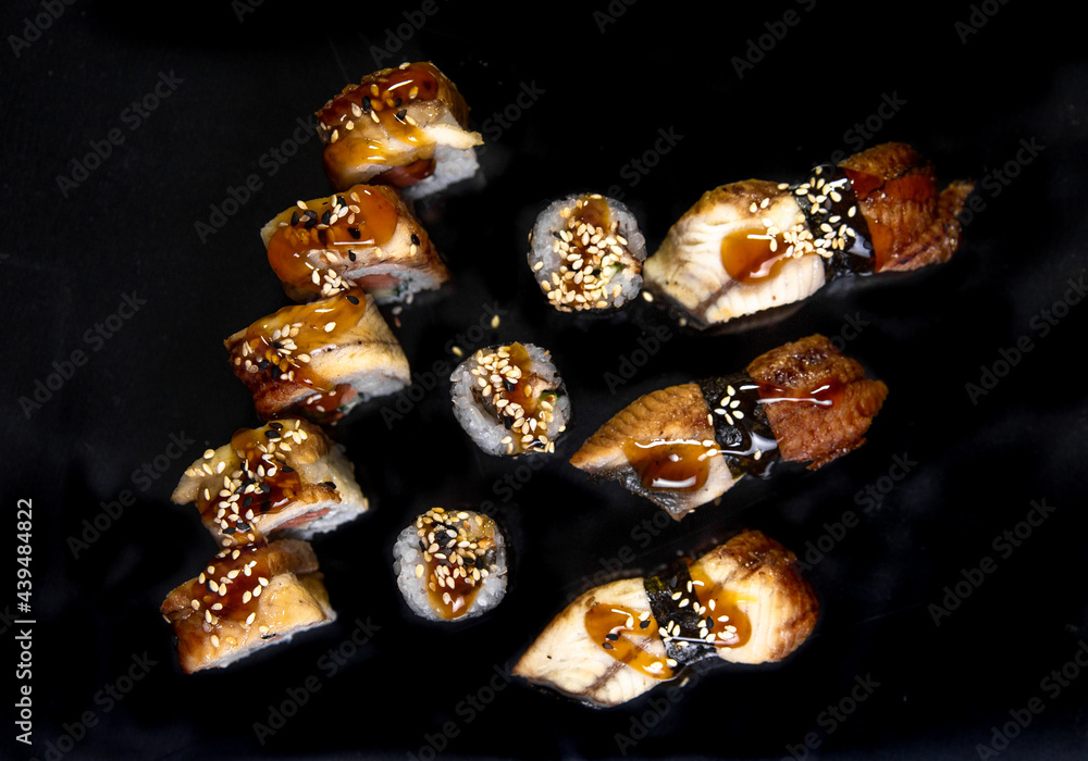 top view baked rolls and sushi on a black background top view baked rolls and sushi on a black background