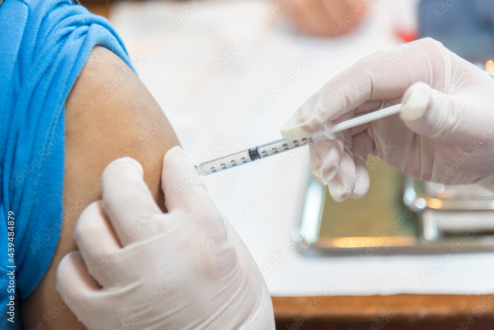 Close up of a Doctor making a vaccination in the shoulder of patient, Flu Vaccination Injection on Arm covid-19 vaccine disease preparing for human clinical trials vaccination shot Close up of a Doctor making a vaccination in the shoulder of patient, Flu Vaccination Injection on Arm covid-19 vaccine disease preparing for human clinical trials vaccination shot