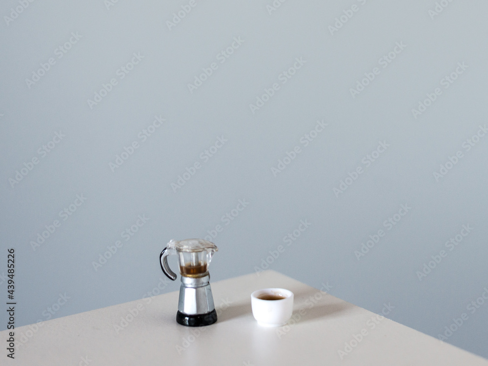 Coffee pot and coffee cup on a white table Coffee pot and coffee cup on a white table