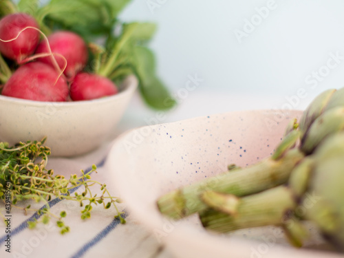 Ceramic crockery with radishes, thyme and artichockes photo