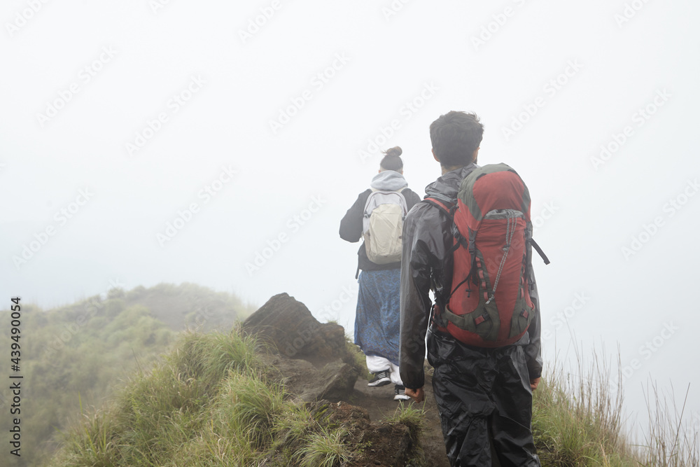Girl and a man are walking along the top of the volcano Girl and a man are walking along the top of the volcano