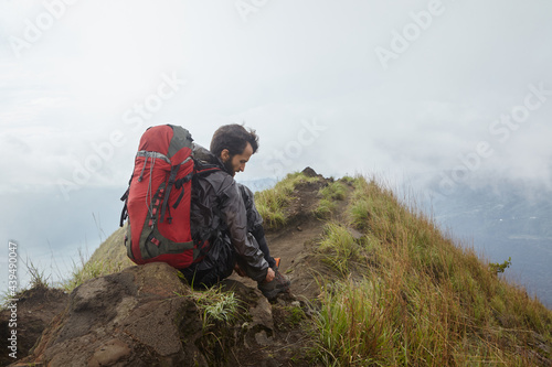 A man with a backpack on the mountain during a halt