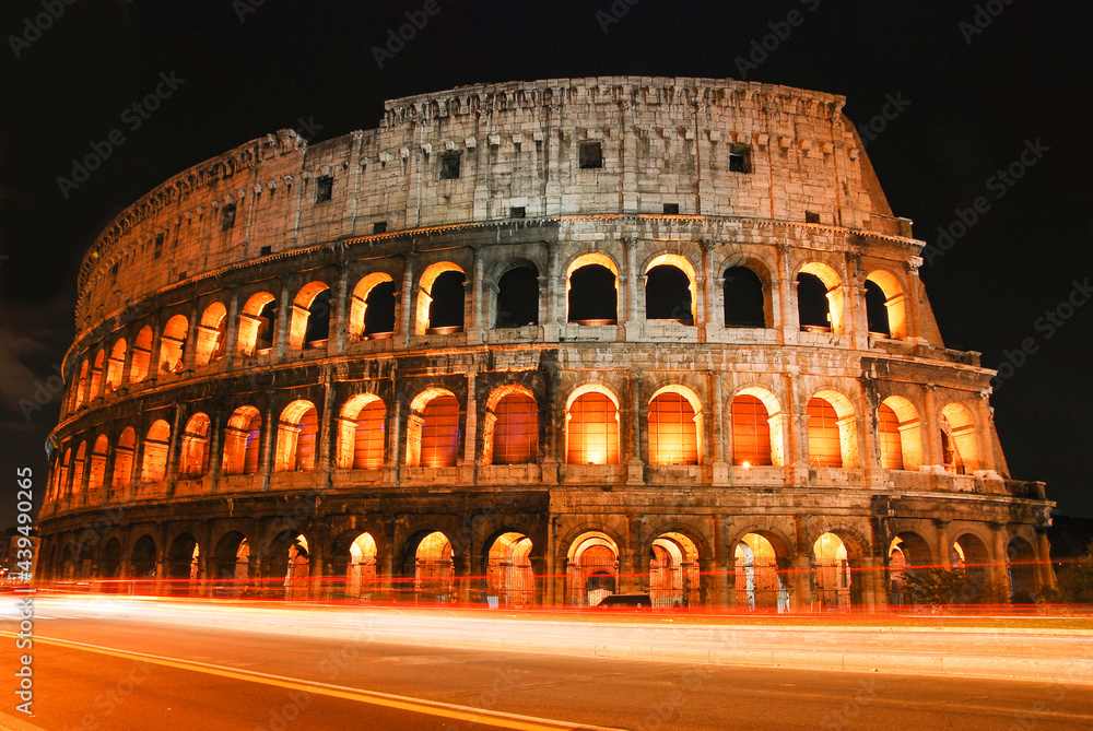 night view of Colosseum, with trails of passing vehicle. Rome