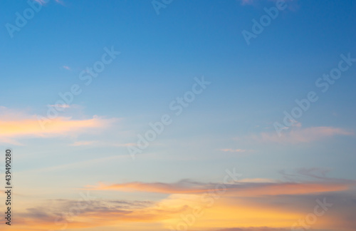 Beautiful sky painted by the sun leaving bright golden shades.Dense clouds in twilight sky in winter evening.Image of cloud sky on evening time.Evening sky scene with golden light from the setting sun © Chalermwoot