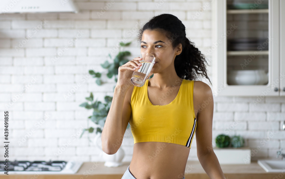 Young African American woman with beautiful body drinks fresh clean water  after fitness workout standing in the home kitchen healthy lifestyle Stock  Photo | Adobe Stock