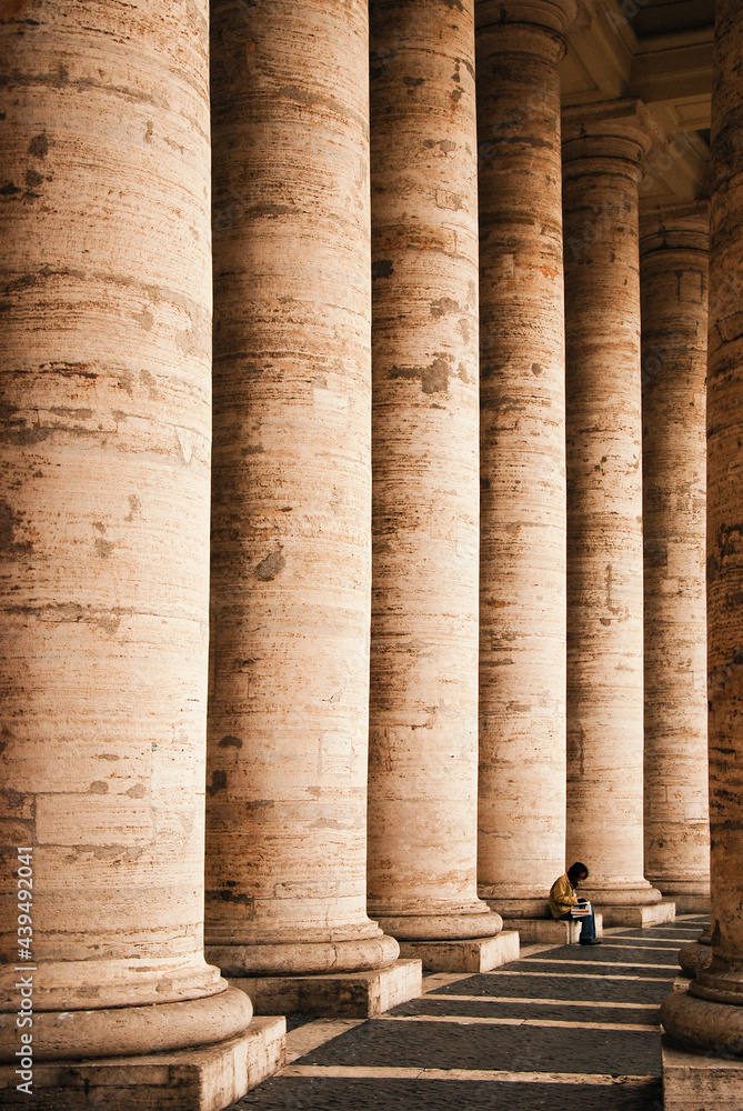 A woman sit below Colonnades of St Peter's Square, reading a book, Vatican A woman sit below Colonnades of St Peter's Square, reading a book, Vatican