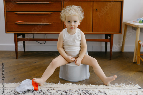 Baby boy potty training indoors photo