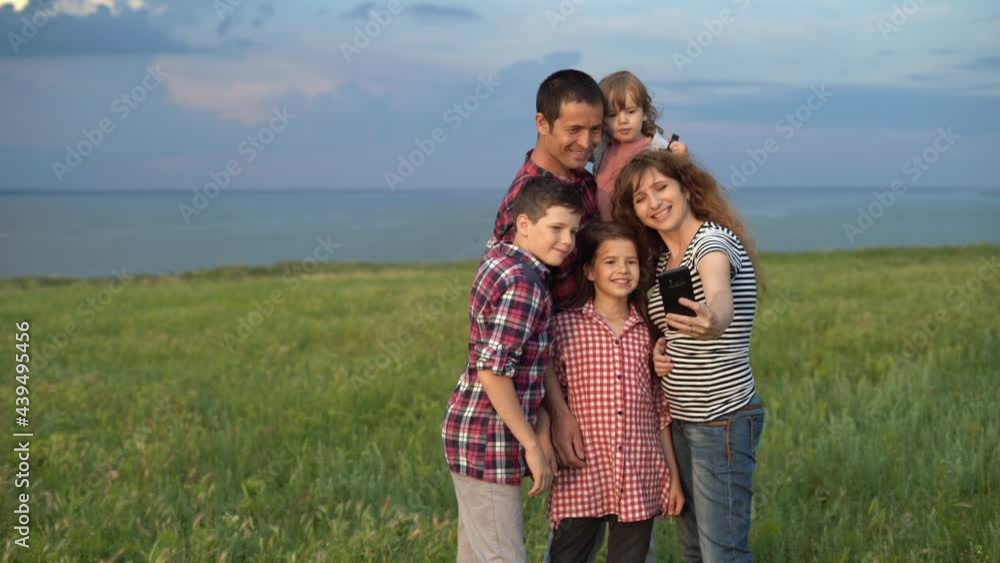 happy big family mother father and children sons and daughters on the lawn make funny selfies on their smartphone. Great vacation for a large family. Copy space. happy big family mother father and children sons and daughters on the lawn make funny selfies on their smartphone. Great vacation for a large family. Copy space.