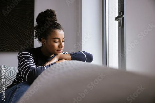 Tender black woman resting on sofa photo