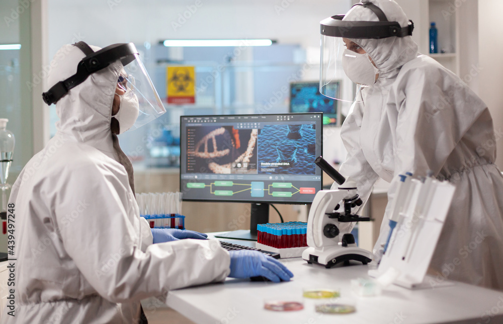Biotechnology scientist wearing ppe suit researching in equipped laboratory.Team doctors working with various bacteria, tissue and blood samples, pharmaceutical research for antibiotics Biotechnology scientist wearing ppe suit researching in equipped laboratory.Team doctors working with various bacteria, tissue and blood samples, pharmaceutical research for antibiotics