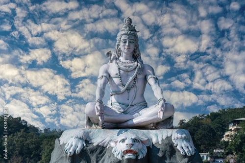 Statue of meditating Hindu god Shiva on the Ganges River at Rishikesh village in India