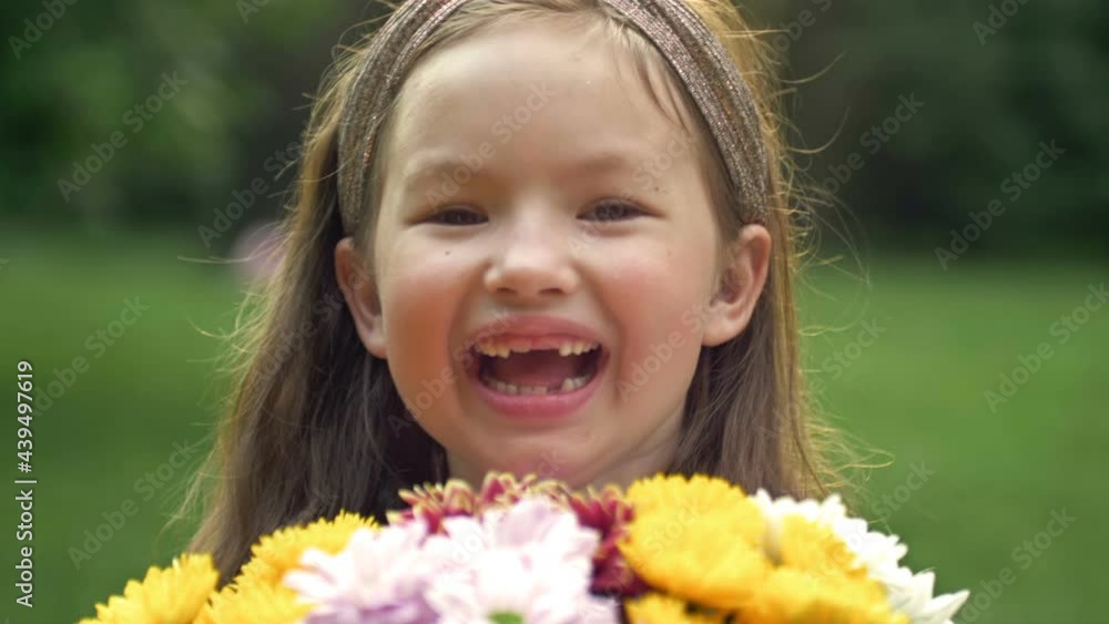 Summer portrait of a cheerful girl 6-7 years old with a bouquet of flowers. Close-up. Summer portrait of a cheerful girl 6-7 years old with a bouquet of flowers. Close-up.