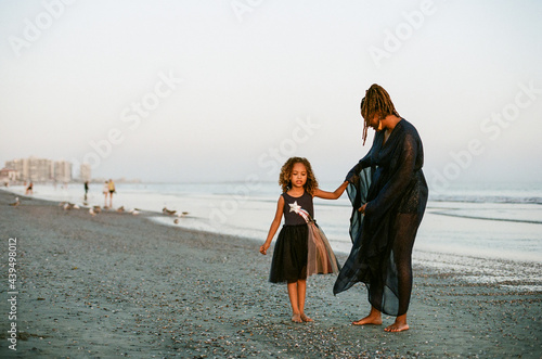 Mother and daughter on beach at sunset photo