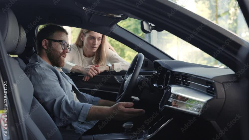 Man sitting in car and examining while seller talking near Man sitting in car and examining while seller talking near