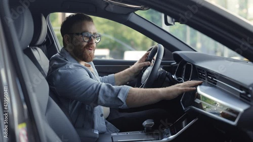 Bearded man testing salon of new auto at dealership photo