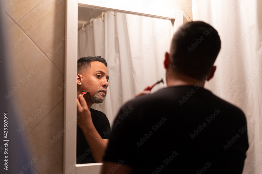 hispanic latino man shaving himself in the bathroom