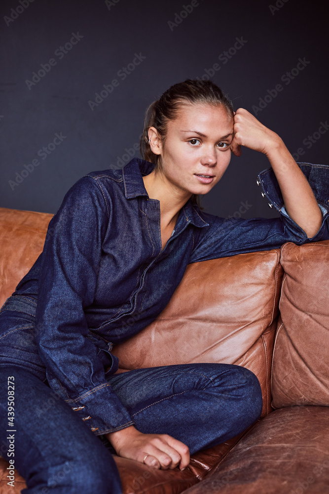 Fashionable young woman sitting on a sofa Fashionable young woman sitting on a sofa