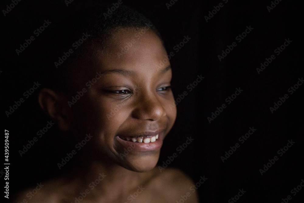 Dark portrait of smiling black boy
Dark portrait of smiling black boy