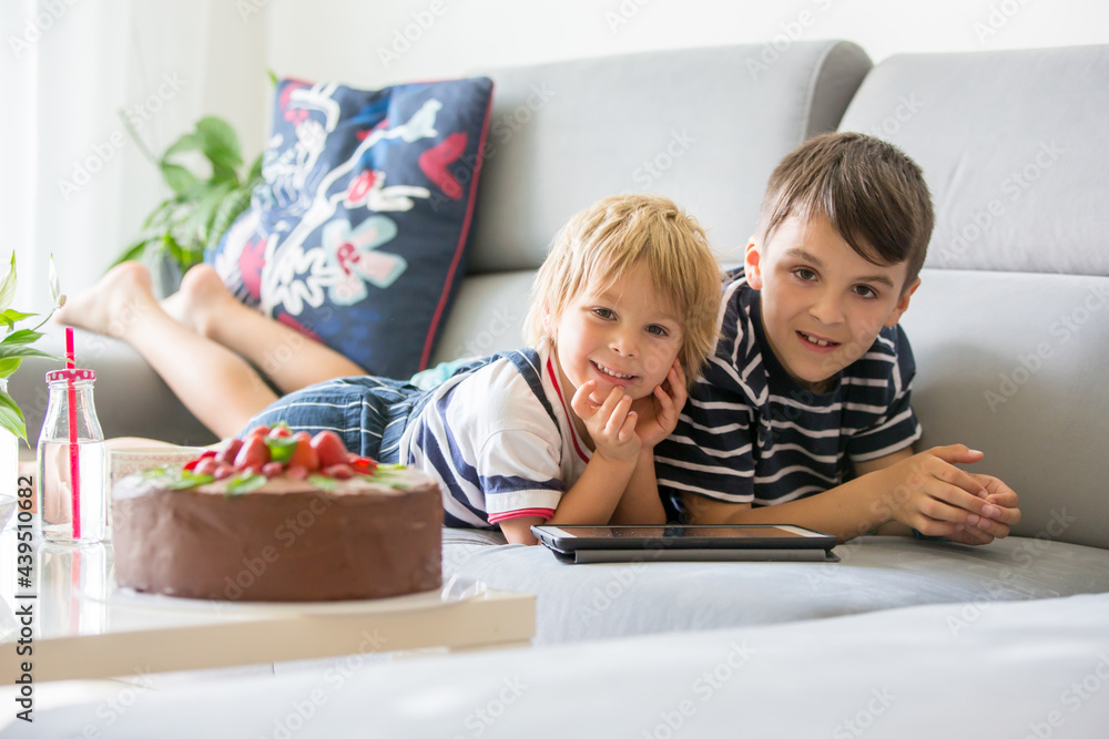 Toddler boy and older brother, watching movie on tablet at home Toddler boy and older brother, watching movie on tablet at home