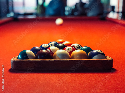 Billiards rack with balls on red billiards table photo