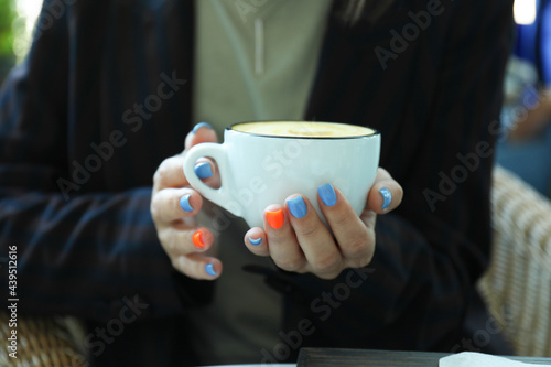 Woman holds cup of delicious coffee, close up