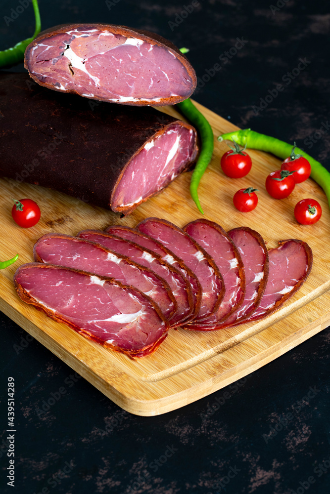 Turkish pastrami on a wooden serving plate. Pastrami is made from the