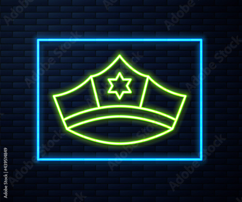 Glowing neon line Police cap with cockade icon isolated on brick wall background. Police hat sign. Vector
