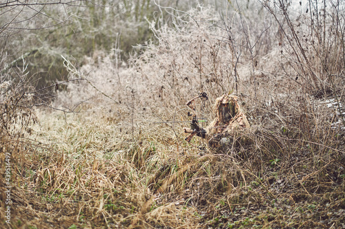 Bow hunter in ghillie suit photo