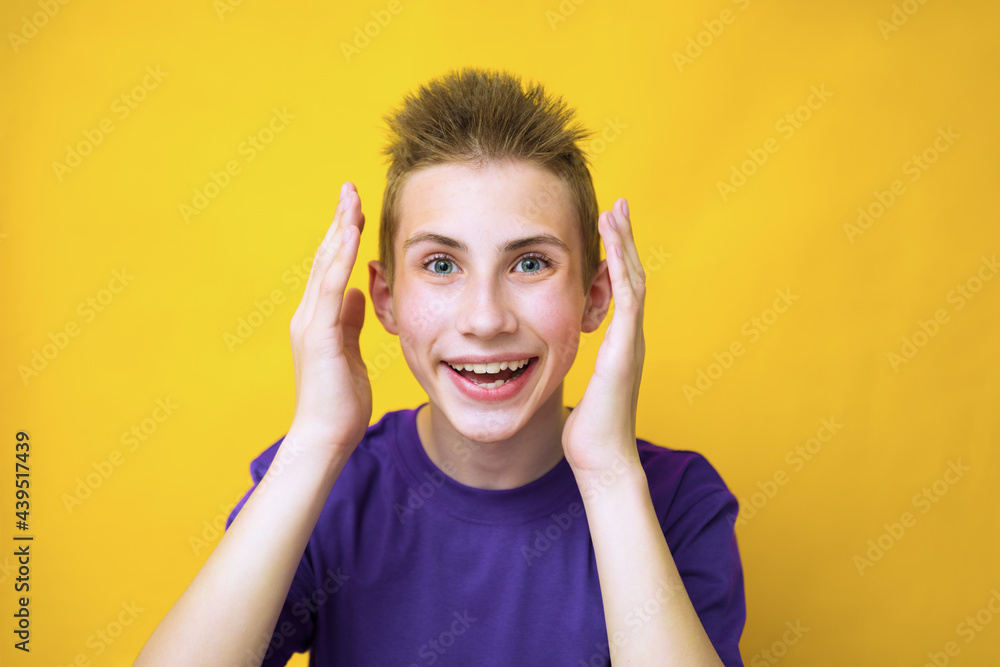 Oh my god, wow! Portrait of amazed teen boy in blue t-shirt staring at camera with big eyes and open mouth, absolutely shocked by news. Indoor studio shot isolated on yellow background Oh my god, wow! Portrait of amazed teen boy in blue t-shirt staring at camera with big eyes and open mouth, absolutely shocked by news. Indoor studio shot isolated on yellow background