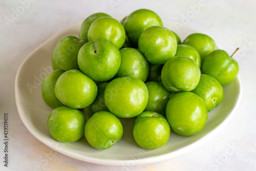 Green plum on a white background.