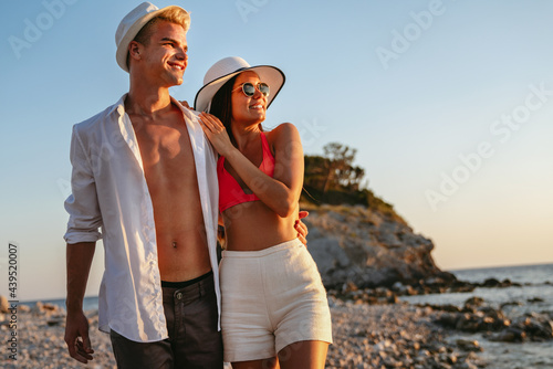 Attractive couple walking on beautiful beach, enjoying summer vacation