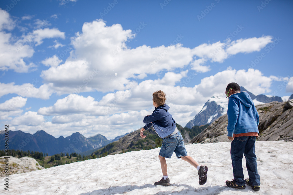 Boys throw snow in mountains Boys throw snow in mountains