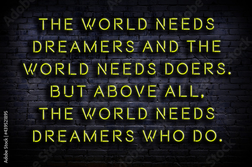 Night view of neon sign on brick wall. Wise qoutation.