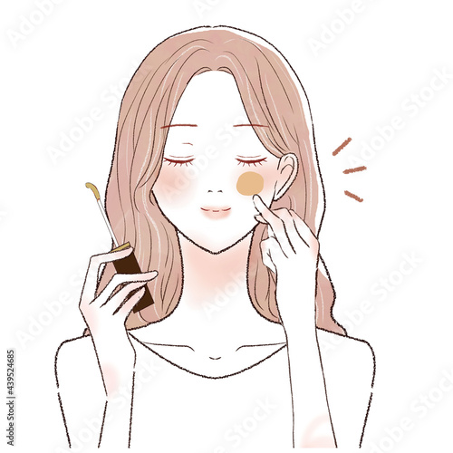 コンシーラーを顔に塗る女性