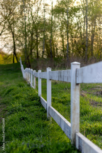 old wooden fence on the lawn at countryside at sunset