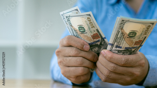Businessman counting American dollars, by hand. Income and business concept.