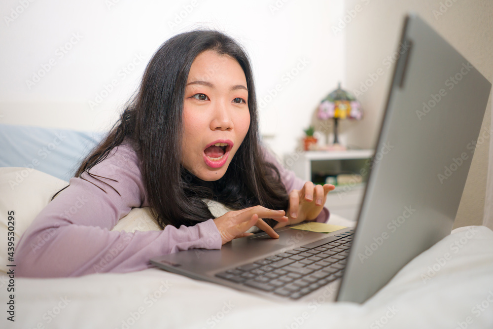 young beautiful Asian woman working with laptop on bed - lifestyle home portrait of young pretty and happy Japanese student girl networking excited with computer young beautiful Asian woman working with laptop on bed - lifestyle home portrait of young pretty and happy Japanese student girl networking excited with computer
