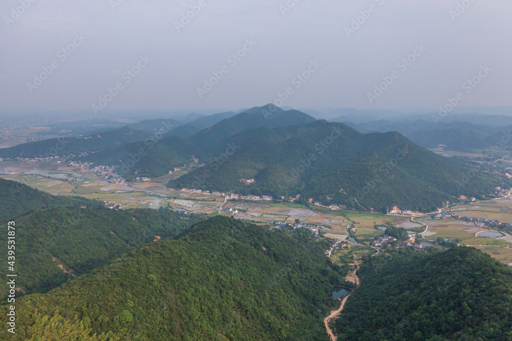 China's rural landscape surrounded by mountains. An aerial view of the forest.