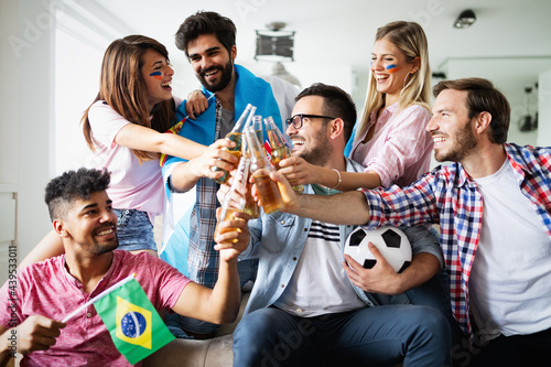 Group of friends sport fans watching soccer match toast