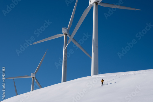 a  person skiing at a wind farm photo