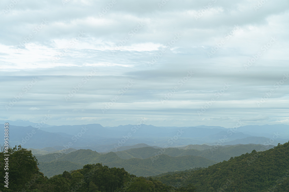 Obraz premium A photograph from a mountain peak in Asia. The early morning clouds that had not yet shined on the undulating mountains.