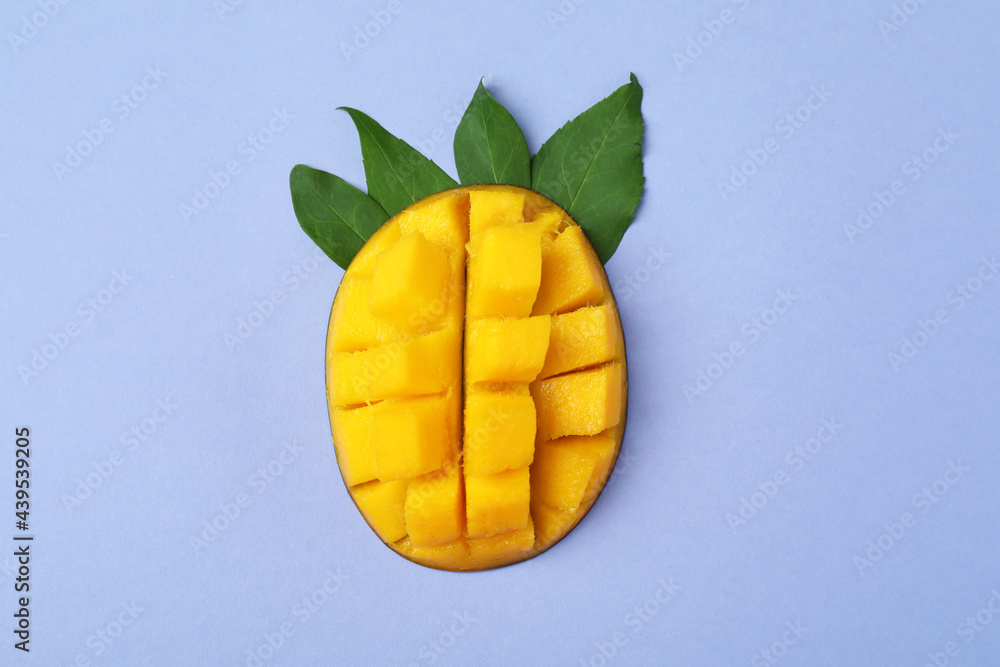 Tasty ripe mango fruit on violet background