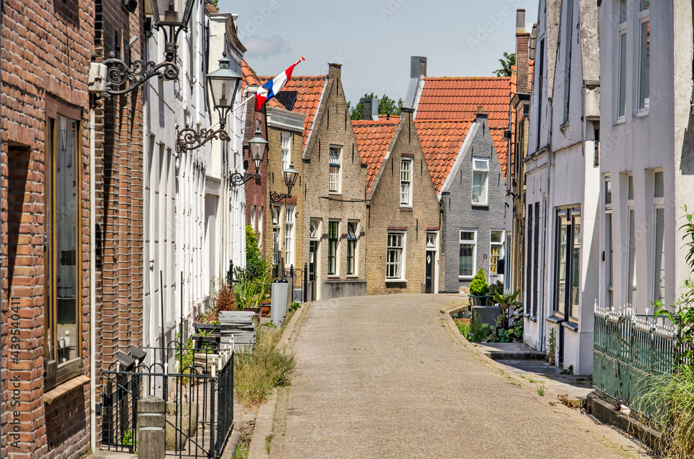 Zwartewaal, The Netherlands, June 12, 2021: traditional houses with brick and plaster facades in the village's main street on a sunny day