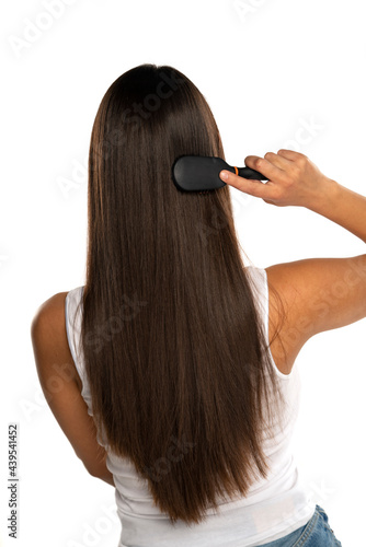 rear view of a young woman brushing her straight long hair