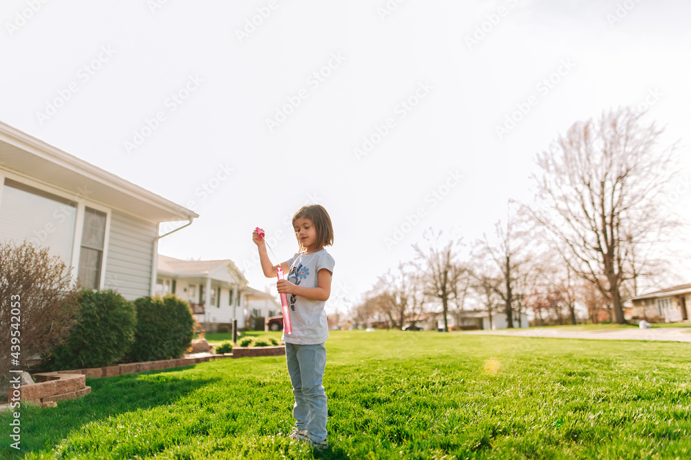 Little girl blowing bubbles with a wand. Little girl blowing bubbles with a wand.