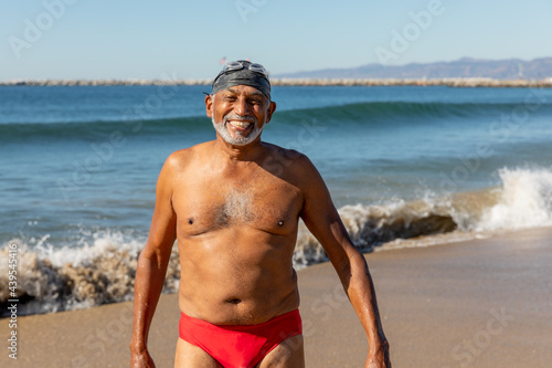 Man Stands in His Bathing Suit At the Beach