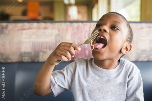 Boy eats noodle at restaurant
