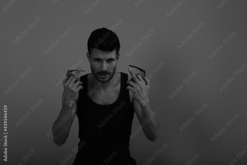 Angry man with two grenades in his hands in black and white Angry man with two grenades in his hands in black and white