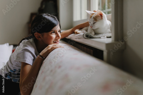 Teen girl at home with cat 