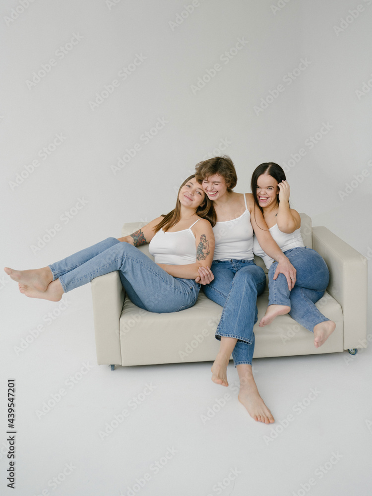 Cheerful multiracial young friends sitting on sofa Cheerful multiracial young friends sitting on sofa